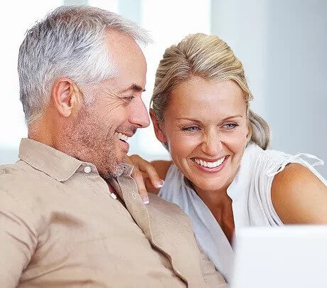 Middle-Age-Couple-Smiling at Test Results on Computer Screen